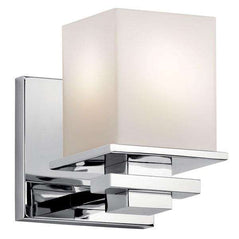 Kichler Tully 1-light wall sconce in chrome finish with a modern design, mounted on a wall with a clear glass shade.